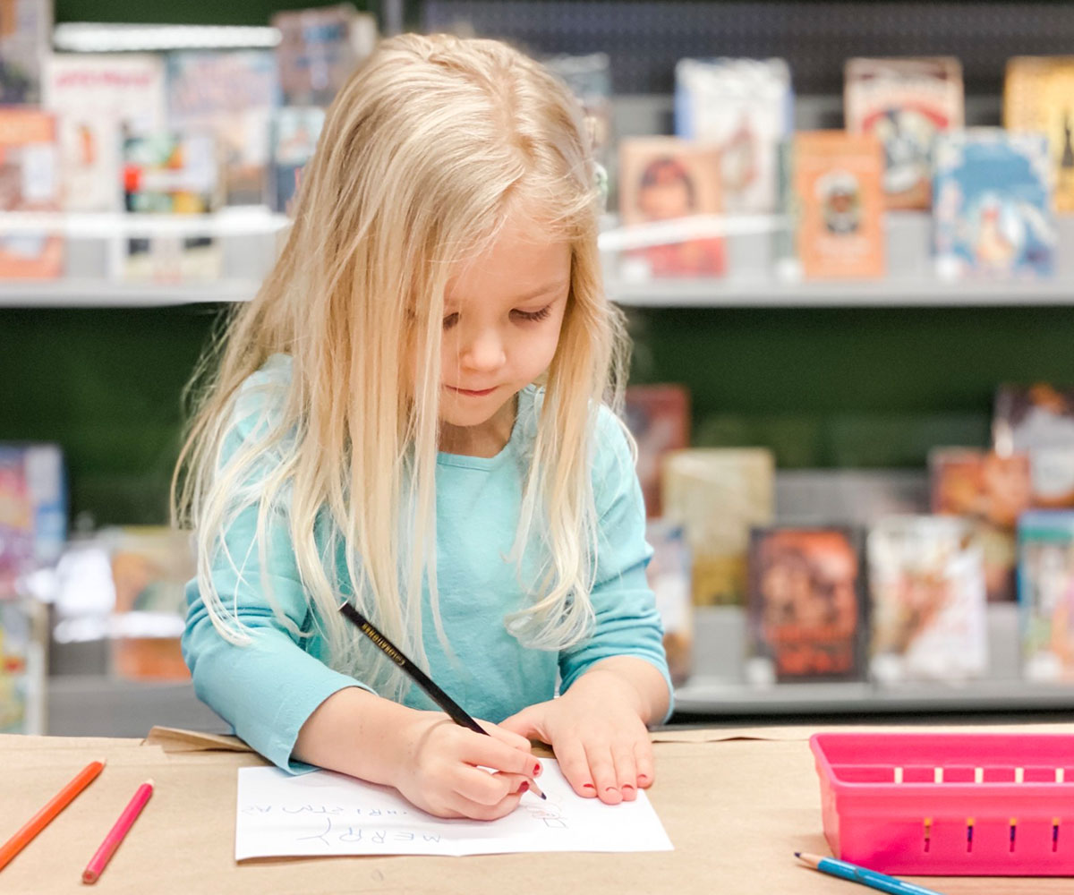 little girl drawing on paper at Buckets ELC childcare centre